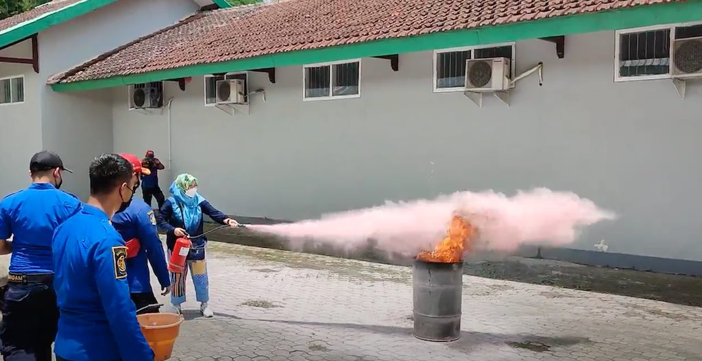 Dekan FKM Unej, Dr. Farida Wahyu Ningtyias, S.KM. M.Kes. sedang praktik mencoba memadamkan api menggunakan APAR